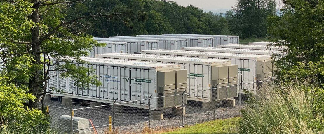 are battery energy storage system safe? image shows a dozen metal containers holding the batteries, behind a security fence